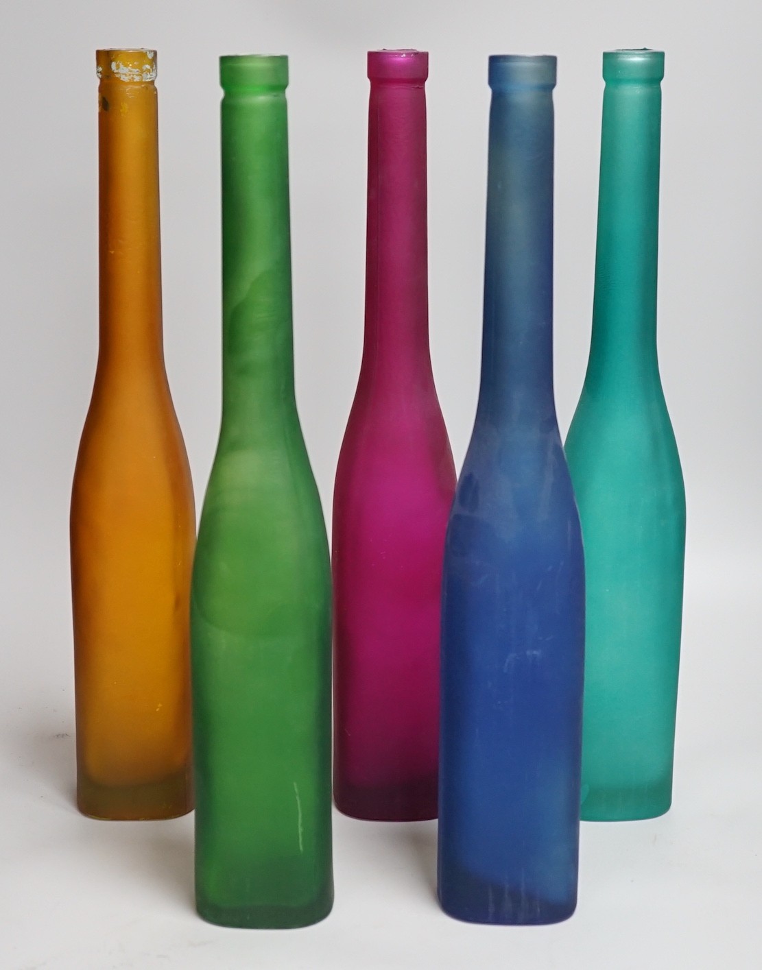 Five coloured glass bottle-neck vases, 42cms high